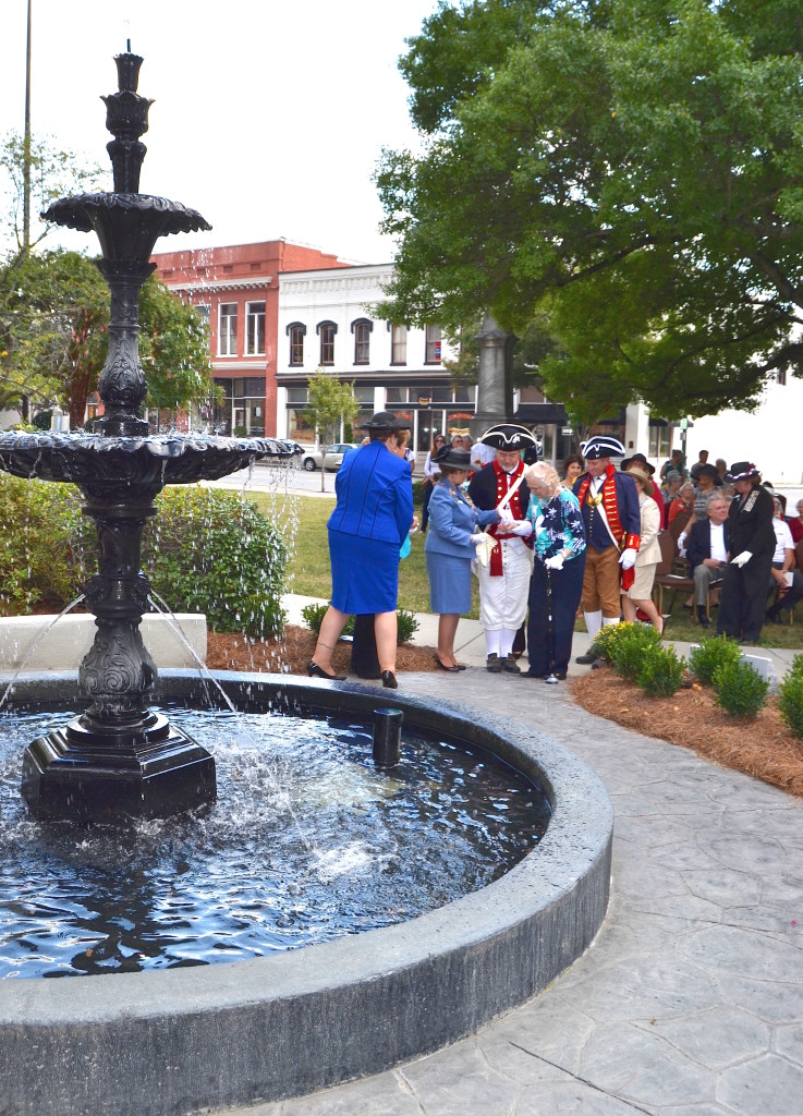 Mecklenburg SAR members Dave Alls, Ken Luckey, North Carolina SAR president Tim Berly, Jim Tatum and Jay Joyce escort DAR members to place original coins back into the fountain during the rededication ceremony.