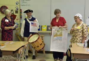 Rolf Maris, and his wife Becky, a DAR member, along with two school teachers, explain the posters to the class.